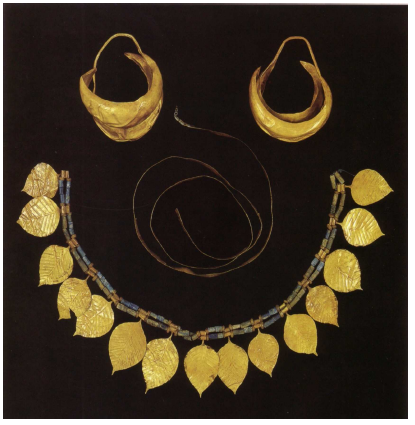 Figure 29- Cimetière Royal d’Ur, parure du corps 54, tombe 1237 : boucles d’oreilles en forme de lune, ruban au centre, en bas couronne à feuille de chêne en or (d’après Aruz 