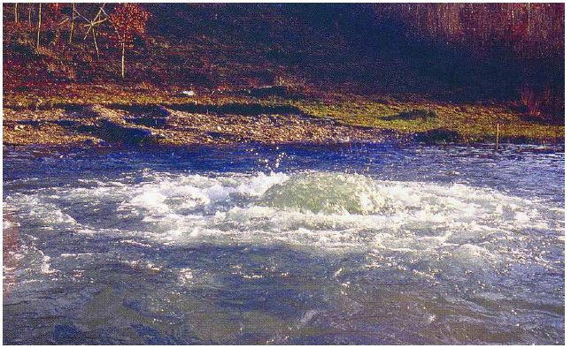 Fig. 21: Picture of the river in spate with geyser coming out of the chasm, situated next to the small sanctuary. Thomas, 2003, p. 31.
